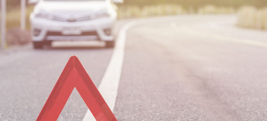 triangulo de asistencia y coche de fondo en una carretera
