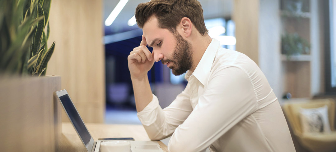 Hombre pensativo trabajando con un ordenador