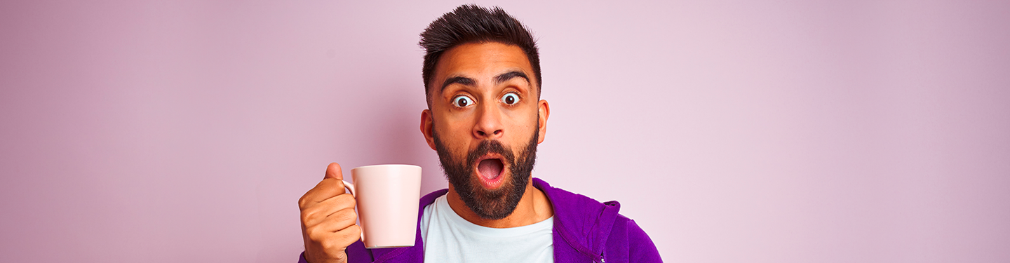 Hombre sorprendido con una taza de la mano