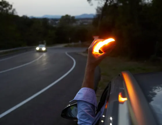 Persona desde el coche colocando una baliza en la parte superior de un coche