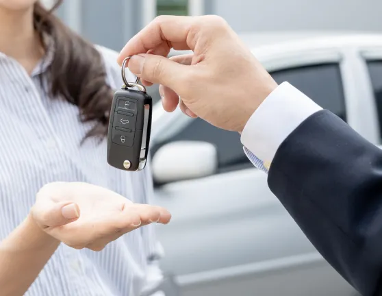 Persona dando las llaves de un coche en la mano de otra persona