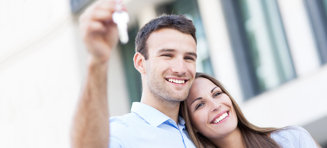 Pareja feliz sosteniendo una llave
